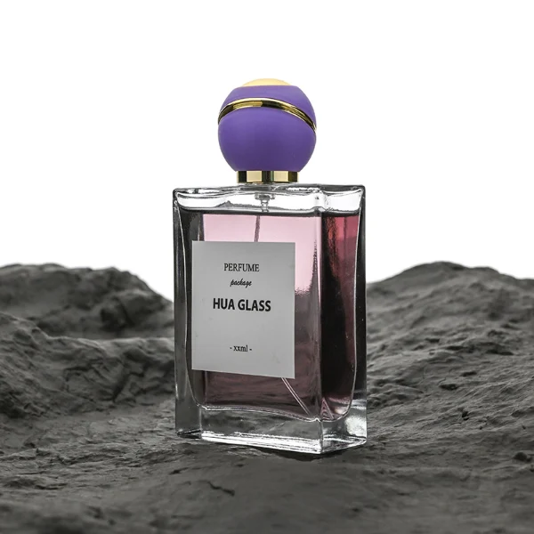 HUA0171 perfume bottle, rectangular transparent glass body with 30 ml, 50 ml, or 100 ml liquid, spherical plastic cap with diagonal gold stripe detailing and gold neck ring, outer label with printed logo, modern elegant design, ideal for gifting and daily use.