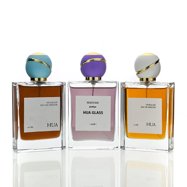 HUA0171 perfume bottle, rectangular transparent glass body with 30 ml, 50 ml, or 100 ml liquid, spherical plastic cap with diagonal gold stripe detailing and gold neck ring, outer label with printed logo, modern elegant design, ideal for gifting and daily use.