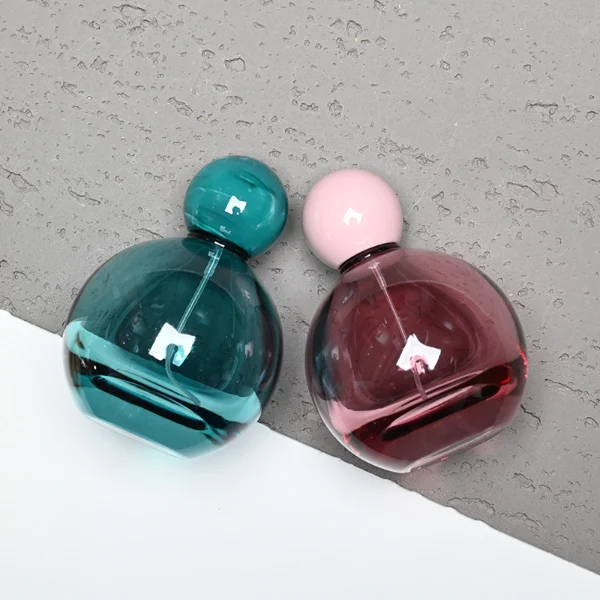 HUA0180 perfume bottle, round gourd-shaped glass body with customizable transparent colors, 30 ml, 50 ml, or 100 ml liquid, glossy spherical plastic cap with customizable colors, custom printed logo, modern playful elegant design, ideal for gifting and daily use.