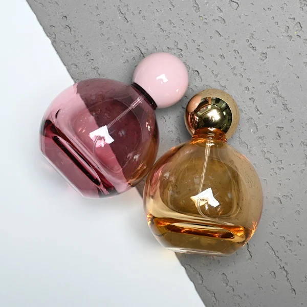 HUA0180 perfume bottle, round gourd-shaped glass body with customizable transparent colors, 30 ml, 50 ml, or 100 ml liquid, glossy spherical plastic cap with customizable colors, custom printed logo, modern playful elegant design, ideal for gifting and daily use.