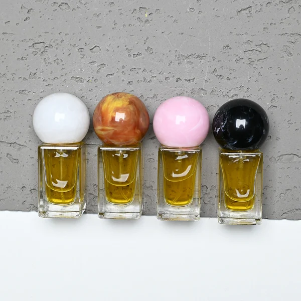 HUA0181 perfume bottle, rectangular faceted transparent glass body with 15 ml, 30 ml, 50 ml, or 100 ml liquid, glossy spherical resin cap with marble-inspired texture and customizable colors, printed logo label, modern artistic luxury design, ideal for gifting and daily use.