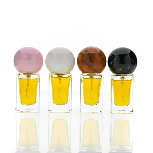 HUA0181 perfume bottle, rectangular faceted transparent glass body with 15 ml, 30 ml, 50 ml, or 100 ml liquid, glossy spherical resin cap with marble-inspired texture and customizable colors, printed logo label, modern artistic luxury design, ideal for gifting and daily use.