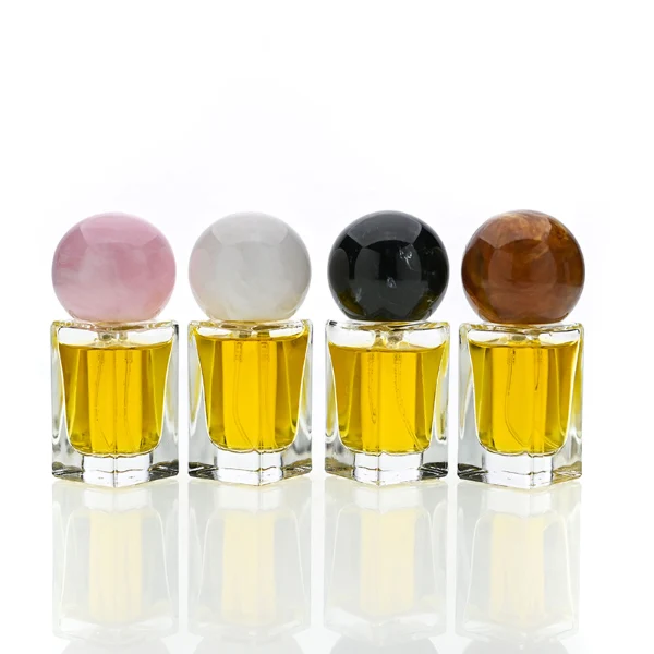 HUA0181 perfume bottle, rectangular faceted transparent glass body with 15 ml, 30 ml, 50 ml, or 100 ml liquid, glossy spherical resin cap with marble-inspired texture and customizable colors, printed logo label, modern artistic luxury design, ideal for gifting and daily use.