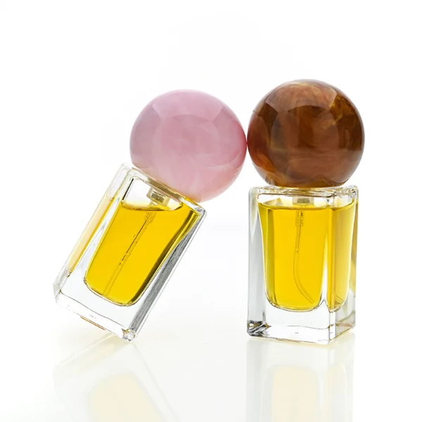 HUA0181 perfume bottle, rectangular faceted transparent glass body with 15 ml, 30 ml, 50 ml, or 100 ml liquid, glossy spherical resin cap with marble-inspired texture and customizable colors, printed logo label, modern artistic luxury design, ideal for gifting and daily use.