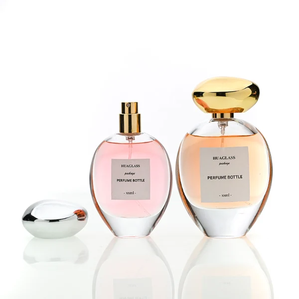 HUA0182 perfume bottle, oval transparent glass body with 30 ml, 50 ml, 75 ml, or 100 ml liquid, irregular oval-shaped glossy plastic cap with gold neck, printed logo label, modern elegant luxury design, ideal for gifting and daily use.