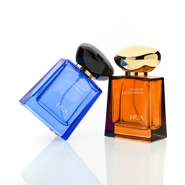HUA0185 perfume bottle, trapezoidal transparent glass body with 50 ml or 100 ml liquid, irregular oval-shaped glossy plastic cap with customizable colors and gold neck, printed glass logo, modern fashionable luxury design, ideal for gifting and daily use.