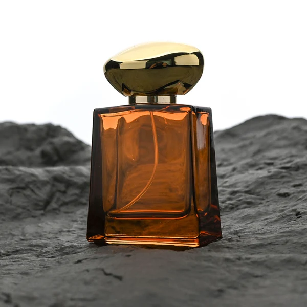 HUA0185 perfume bottle, trapezoidal transparent glass body with 50 ml or 100 ml liquid, irregular oval-shaped glossy plastic cap with customizable colors and gold neck, printed glass logo, modern fashionable luxury design, ideal for gifting and daily use.