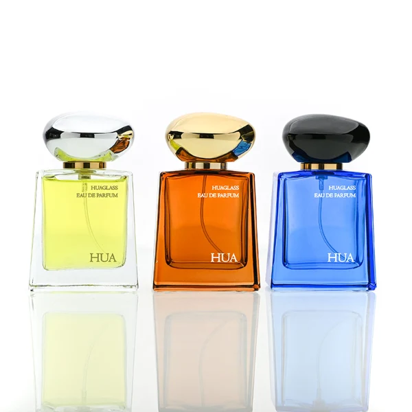 HUA0185 perfume bottle, trapezoidal transparent glass body with 50 ml or 100 ml liquid, irregular oval-shaped glossy plastic cap with customizable colors and gold neck, printed glass logo, modern fashionable luxury design, ideal for gifting and daily use.