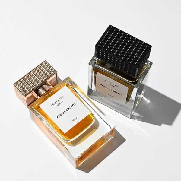 HUA0189 perfume bottle, rectangular transparent glass body with 50 ml liquid, rectangular textured plastic cap with customizable color matching the neck, printed logo label, modern premium luxury design, ideal for gifting and daily use.
