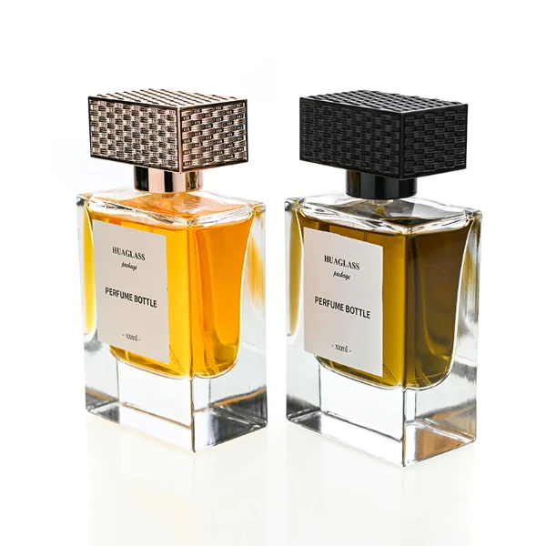 HUA0189 perfume bottle, rectangular transparent glass body with 50 ml liquid, rectangular textured plastic cap with customizable color matching the neck, printed logo label, modern premium luxury design, ideal for gifting and daily use.