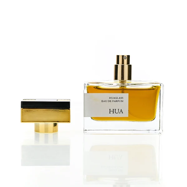 HUA0190 perfume bottle, rectangular transparent glass body with 50 ml liquid, rectangular plastic cap with customizable color matching the neck, printed logo label, modern premium luxury design, ideal for gifting and daily use.