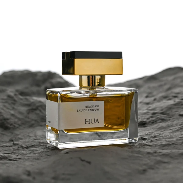 HUA0190 perfume bottle, rectangular transparent glass body with 50 ml liquid, rectangular plastic cap with customizable color matching the neck, printed logo label, modern premium luxury design, ideal for gifting and daily use.