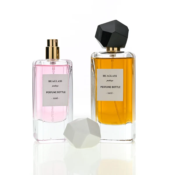 HUA0192 perfume bottle, rectangular transparent glass body with 50 ml or 80 ml liquid, irregular faceted geometric plastic cap with gold neck, printed logo label, modern artistic luxury design, ideal for gifting and daily use.