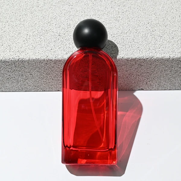 HUA0194 perfume bottle, rounded rectangular transparent glass body with customizable colors, 30 ml, 50 ml, or 100 ml liquid, black spherical plastic cap, private printed logo, modern minimalist design, ideal for gifting and daily use.