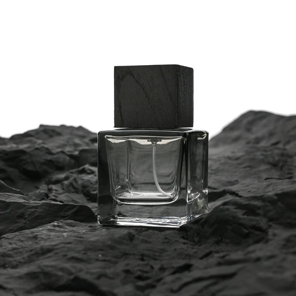 HUA0199 perfume bottle, square gradient glass body with 30 ml, 50 ml, or 100 ml liquid, black wooden square cap with removable design, one with gold spray head, one with protective cap, printed logo label, modern minimalist luxury design, ideal for gifting and daily use.