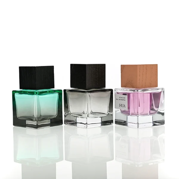 HUA0199 perfume bottle, square gradient glass body with 30 ml, 50 ml, or 100 ml liquid, black wooden square cap with removable design, one with gold spray head, one with protective cap, printed logo label, modern minimalist luxury design, ideal for gifting and daily use.
