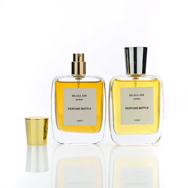 HUA0202 perfume bottle, rectangular transparent glass body with 50 ml or 100 ml liquid, stepped cylindrical plastic cap in black, gold, or silver, brand label applied on the surface, modern minimalist design, ideal for gifting and daily use.