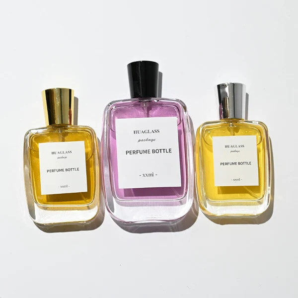 HUA0202 perfume bottle, rectangular transparent glass body with 50 ml or 100 ml liquid, stepped cylindrical plastic cap in black, gold, or silver, brand label applied on the surface, modern minimalist design, ideal for gifting and daily use.