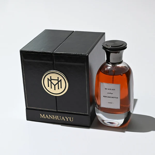 HUA0205 perfume bottle, flattened rounded streamlined transparent glass body with thick base and high-gloss finish, 100 ml liquid, flat cylindrical Zamac cap in black, gold, or silver with slightly enlarged flat top fitting snugly on the neck, brand label applied on the surface, modern luxurious design, ideal for gifting and daily use.