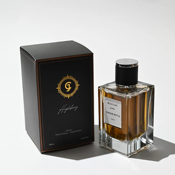 HUA0206 perfume bottle, rectangular transparent glass body with thick base, 50 ml or 100 ml liquid, cylindrical leather-wrapped cap with silver rings on both ends, brand label applied on the surface, modern masculine luxury design, ideal for gifting and daily use.