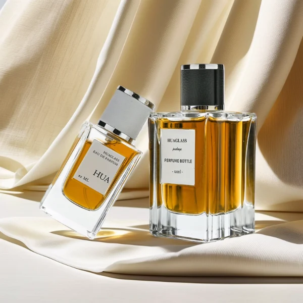 HUA0206 perfume bottle, rectangular transparent glass body with thick base, 50 ml or 100 ml liquid, cylindrical leather-wrapped cap with silver rings on both ends, brand label applied on the surface, modern masculine luxury design, ideal for gifting and daily use.