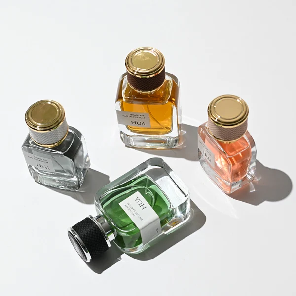 HUA0207 perfume bottle, rectangular transparent glass body with thick base, 30 ml, 50 ml, or 100 ml liquid, cylindrical leather-wrapped cap with customizable colors, brand label applied on the surface, modern luxurious design, ideal for gifting and daily use.