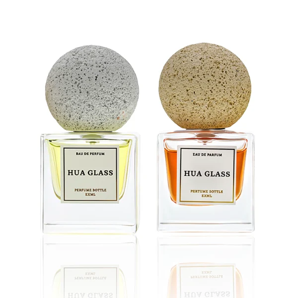 HUA0210 perfume bottle, square transparent glass body with thick base, 30 ml, 50 ml, or 100 ml liquid, spherical artificial stone cap with textured surface, brand label applied on the surface, modern artistic luxury design, ideal for gifting and daily use.