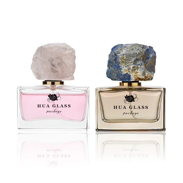 HUA0211 perfume bottle, rectangular customizable glass body with thick base, 30 ml, 50 ml, or 100 ml liquid, rough natural crystal stone cap with gold metallic neck, brand label printed on the surface, modern artistic luxury design, ideal for gifting and daily use.