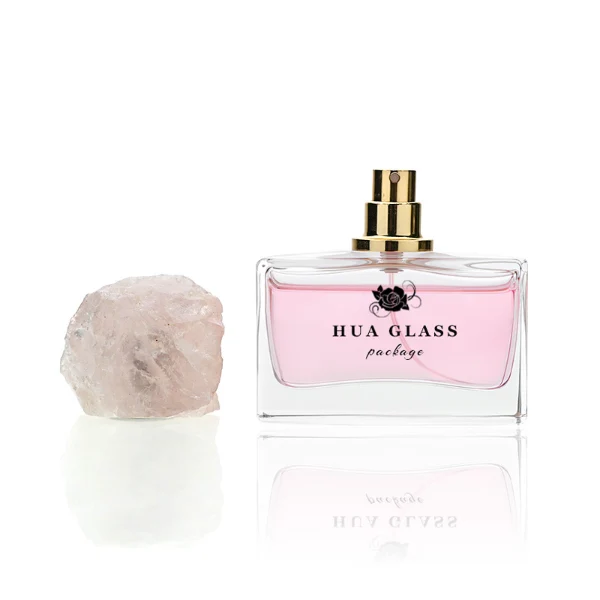 HUA0211 perfume bottle, rectangular customizable glass body with thick base, 30 ml, 50 ml, or 100 ml liquid, rough natural crystal stone cap with gold metallic neck, brand label printed on the surface, modern artistic luxury design, ideal for gifting and daily use.