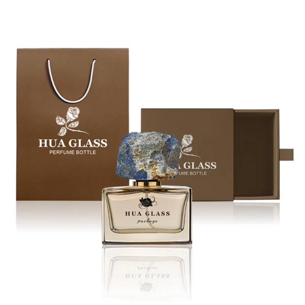 HUA0211 perfume bottle, rectangular customizable glass body with thick base, 30 ml, 50 ml, or 100 ml liquid, rough natural crystal stone cap with gold metallic neck, brand label printed on the surface, modern artistic luxury design, ideal for gifting and daily use.