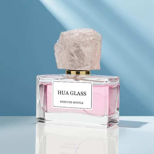 HUA0211 perfume bottle, rectangular customizable glass body with thick base, 30 ml, 50 ml, or 100 ml liquid, rough natural crystal stone cap with gold metallic neck, brand label printed on the surface, modern artistic luxury design, ideal for gifting and daily use.