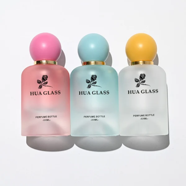 HUA0212 perfume bottle, rounded cylindrical frosted glass body with thick base, 30 ml, 50 ml, or 100 ml liquid, spherical plastic cap in customizable colors with gold neck ring, brand logo printed on the bottle, modern playful luxury design, ideal for gifting and daily use.