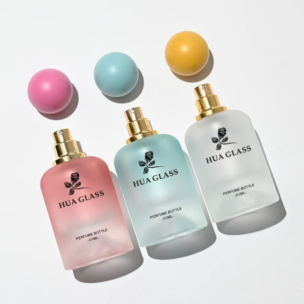HUA0212 perfume bottle, rounded cylindrical frosted glass body with thick base, 30 ml, 50 ml, or 100 ml liquid, spherical plastic cap in customizable colors with gold neck ring, brand logo printed on the bottle, modern playful luxury design, ideal for gifting and daily use.