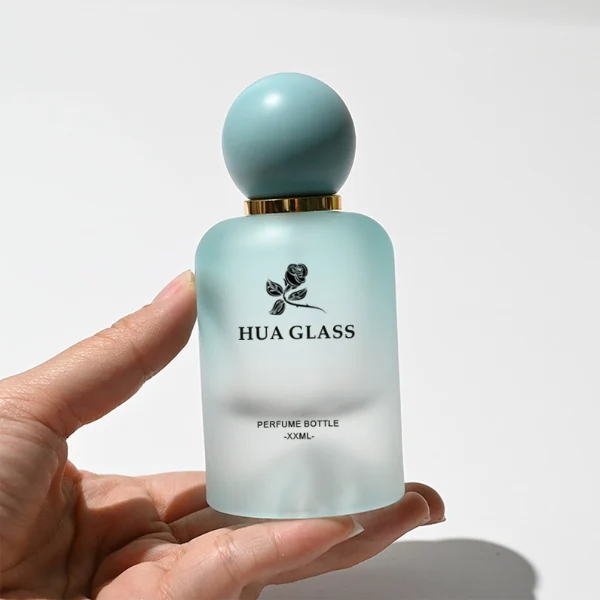 HUA0212 perfume bottle, rounded cylindrical frosted glass body with thick base, 30 ml, 50 ml, or 100 ml liquid, spherical plastic cap in customizable colors with gold neck ring, brand logo printed on the bottle, modern playful luxury design, ideal for gifting and daily use.