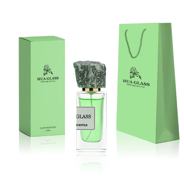 HUA0213 perfume bottle, rectangular transparent glass body with thick base, 30 ml, 50 ml, or 100 ml liquid, rough natural crystal stone cap with gold neck ring, brand label applied on the bottle surface, modern artistic luxury design, ideal for gifting and daily use.