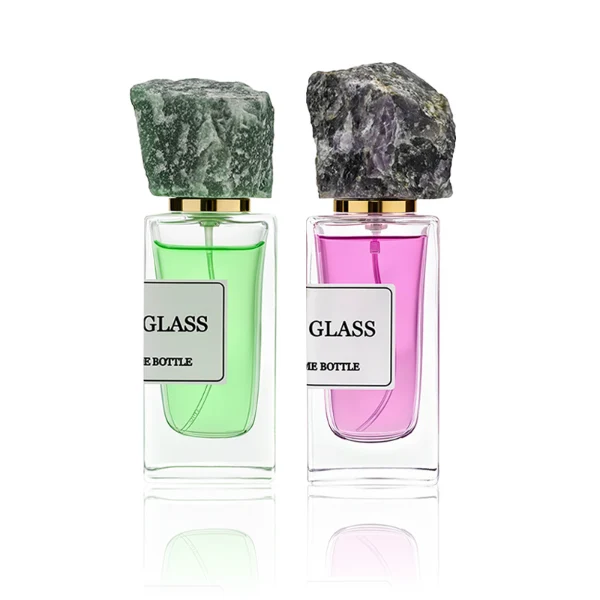 HUA0213 perfume bottle, rectangular transparent glass body with thick base, 30 ml, 50 ml, or 100 ml liquid, rough natural crystal stone cap with gold neck ring, brand label applied on the bottle surface, modern artistic luxury design, ideal for gifting and daily use.