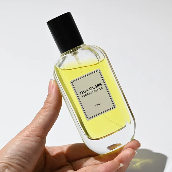 HUA0219 perfume bottle, rounded rectangular transparent glass body with thick base, 50 ml or 100 ml liquid, cylindrical wooden cap in black or natural wood color, brand label applied on bottle, modern elegant fashion design, ideal for gifting and daily use.