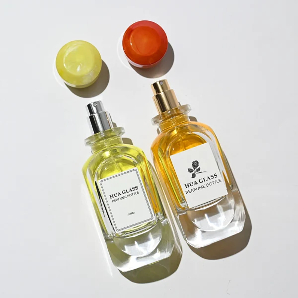 HUA0222 perfume bottle, rounded rectangular transparent glass body with thick base, 80 ml liquid, faceted resin cap with natural marbled pattern and customizable color, brand label applied on bottle, modern luxurious fashion design, ideal for gifting and daily use.