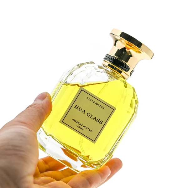 HUA0224 perfume bottle, multifaceted transparent glass body with thick base, 100 ml liquid, cylindrical plastic cap with slightly flared flat top and gold or silver neck ring, brand label applied on bottle, modern luxurious fashion design, ideal for gifting and daily use.