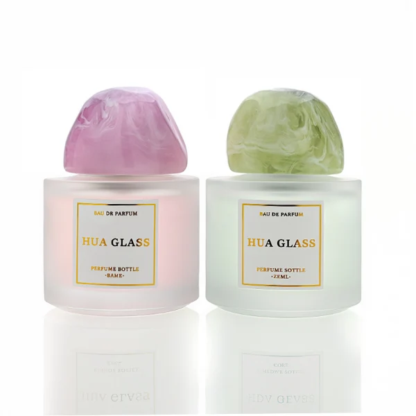 HUA0225 perfume bottle, rounded frosted glass body with thick base, 30 ml, 50 ml, or 100 ml liquid, irregular-shaped resin cap with customizable colors, brand label applied on bottle, modern luxurious fashion design, ideal for gifting and daily use.