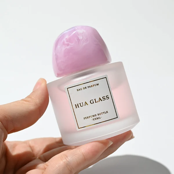 HUA0225 perfume bottle, rounded frosted glass body with thick base, 30 ml, 50 ml, or 100 ml liquid, irregular-shaped resin cap with customizable colors, brand label applied on bottle, modern luxurious fashion design, ideal for gifting and daily use.