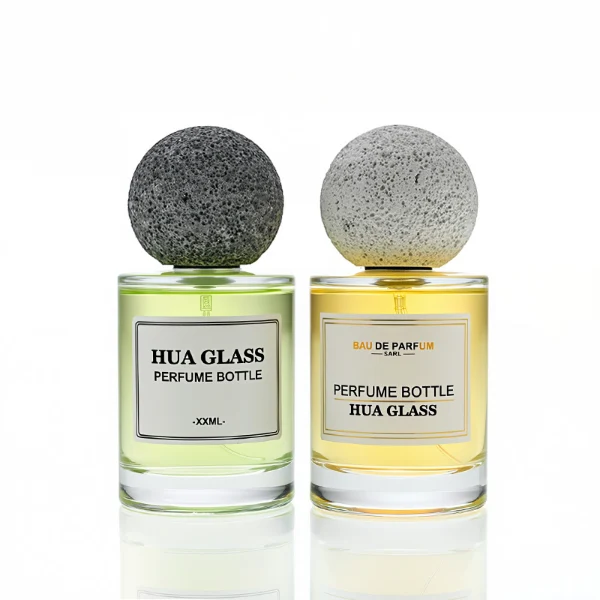 HUA0228 perfume bottle, cylindrical transparent glass body with thick base, 30 ml, 50 ml, or 100 ml liquid, spherical artificial stone cap with natural texture, brand label applied on bottle, modern luxurious fashion design, ideal for gifting and daily use.
