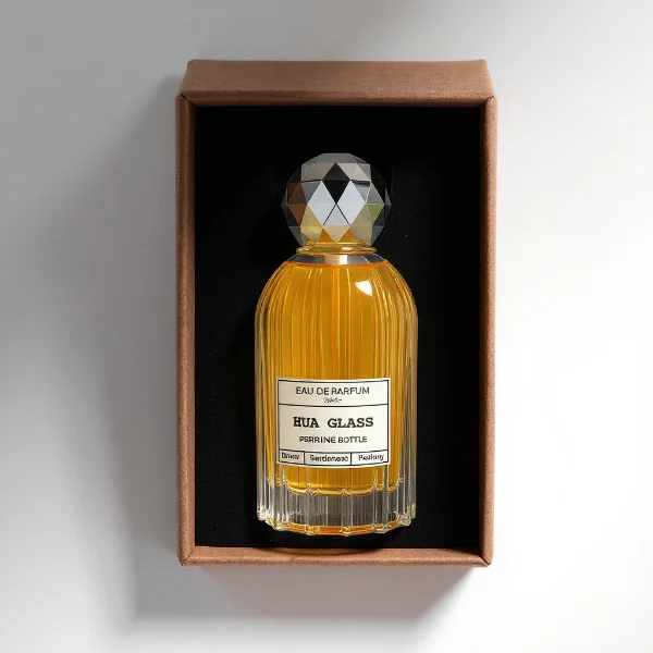 HUA0229 perfume bottle, cylindrical transparent glass body with ribbed sides and thick base, 100 ml liquid, faceted geometric sphere plastic cap in gold or silver, brand label applied on bottle, modern luxurious fashion design, ideal for gifting and daily use.