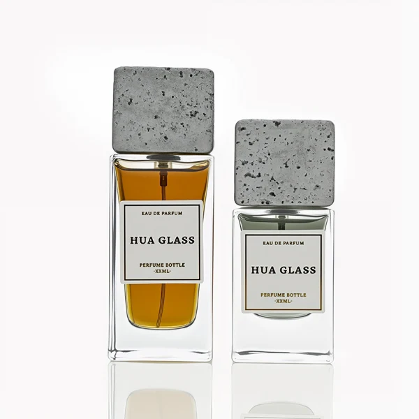 HUA0230 perfume bottle, rectangular transparent glass body with thick base, 30 ml, 50 ml, or 100 ml liquid, square artificial stone cap with natural texture, brand label applied on bottle, modern luxurious fashion design, ideal for gifting and daily use.