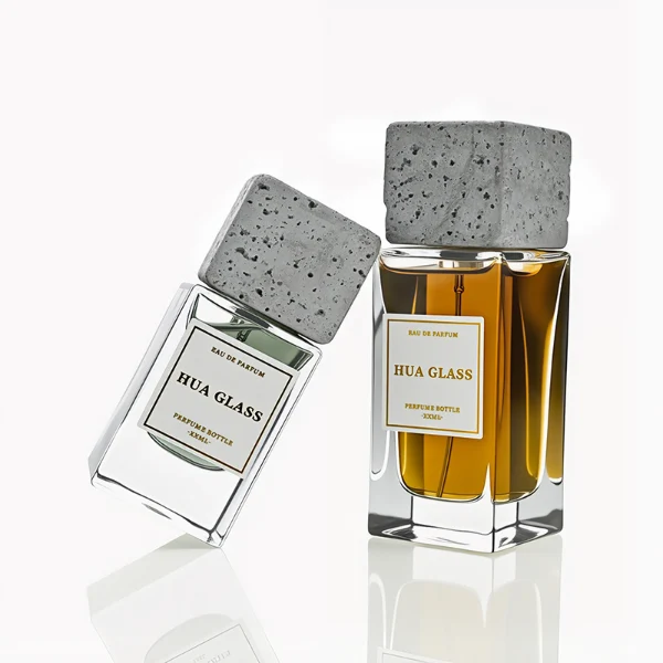 HUA0230 perfume bottle, rectangular transparent glass body with thick base, 30 ml, 50 ml, or 100 ml liquid, square artificial stone cap with natural texture, brand label applied on bottle, modern luxurious fashion design, ideal for gifting and daily use.