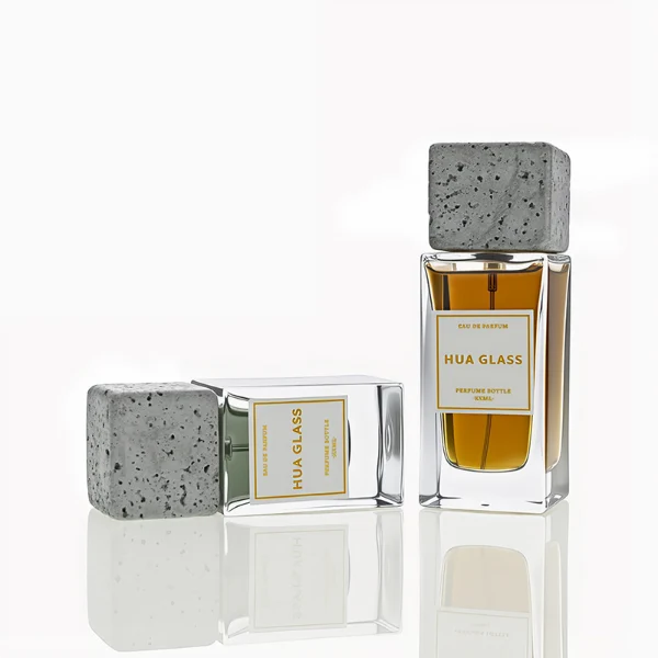 HUA0230 perfume bottle, rectangular transparent glass body with thick base, 30 ml, 50 ml, or 100 ml liquid, square artificial stone cap with natural texture, brand label applied on bottle, modern luxurious fashion design, ideal for gifting and daily use.