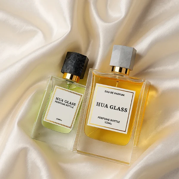 HUA0231 perfume bottle, rectangular transparent glass body with thick base, 30 ml, 50 ml, or 100 ml liquid, irregular natural stone cap with gold neck, brand label applied on bottle, modern luxurious fashion design, ideal for gifting and daily use.