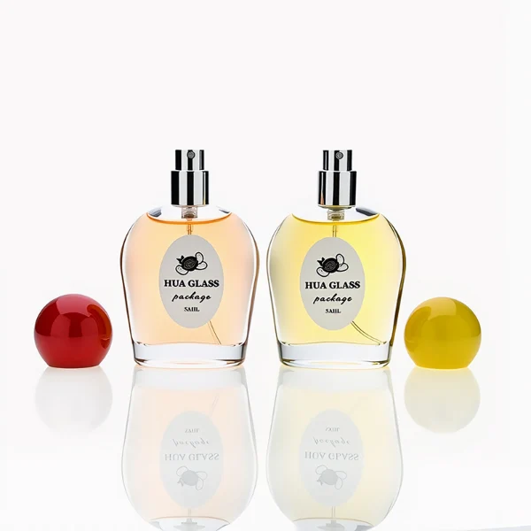 HUA0232 perfume bottle, flattened oval transparent glass body with thick base, high-gloss finish, smooth rounded contours, 50 ml liquid, spherical plastic cap in customizable colors, brand label applied on bottle, modern playful design, ideal for gifting and daily use.