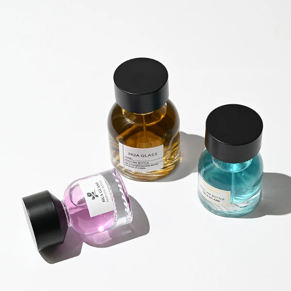 HUA0234 perfume bottle, flattened oval transparent glass body with thick base and smooth rounded contours, 30 ml, 50 ml, or 100 ml liquid, cylindrical plastic cap with flat top, brand label applied on bottle, modern luxurious design, ideal for gifting and daily use.