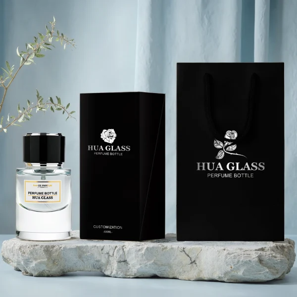 HUA0242 perfume bottle, cylindrical transparent glass body with thick base, 30 ml, 50 ml, or 100 ml liquid, cylindrical plastic cap with black or white side and silver plastic rings on both top and bottom, brand label applied on bottle, modern luxurious design, ideal for gifting and daily use.